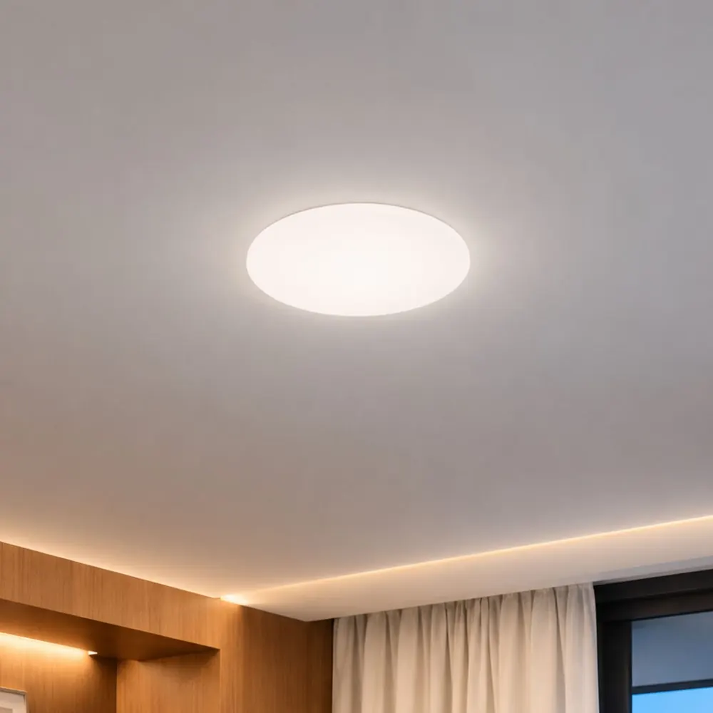 Painel LED Borda Infinita redondo sem moldura aceso em 4000K neutra, no teto de um quarto